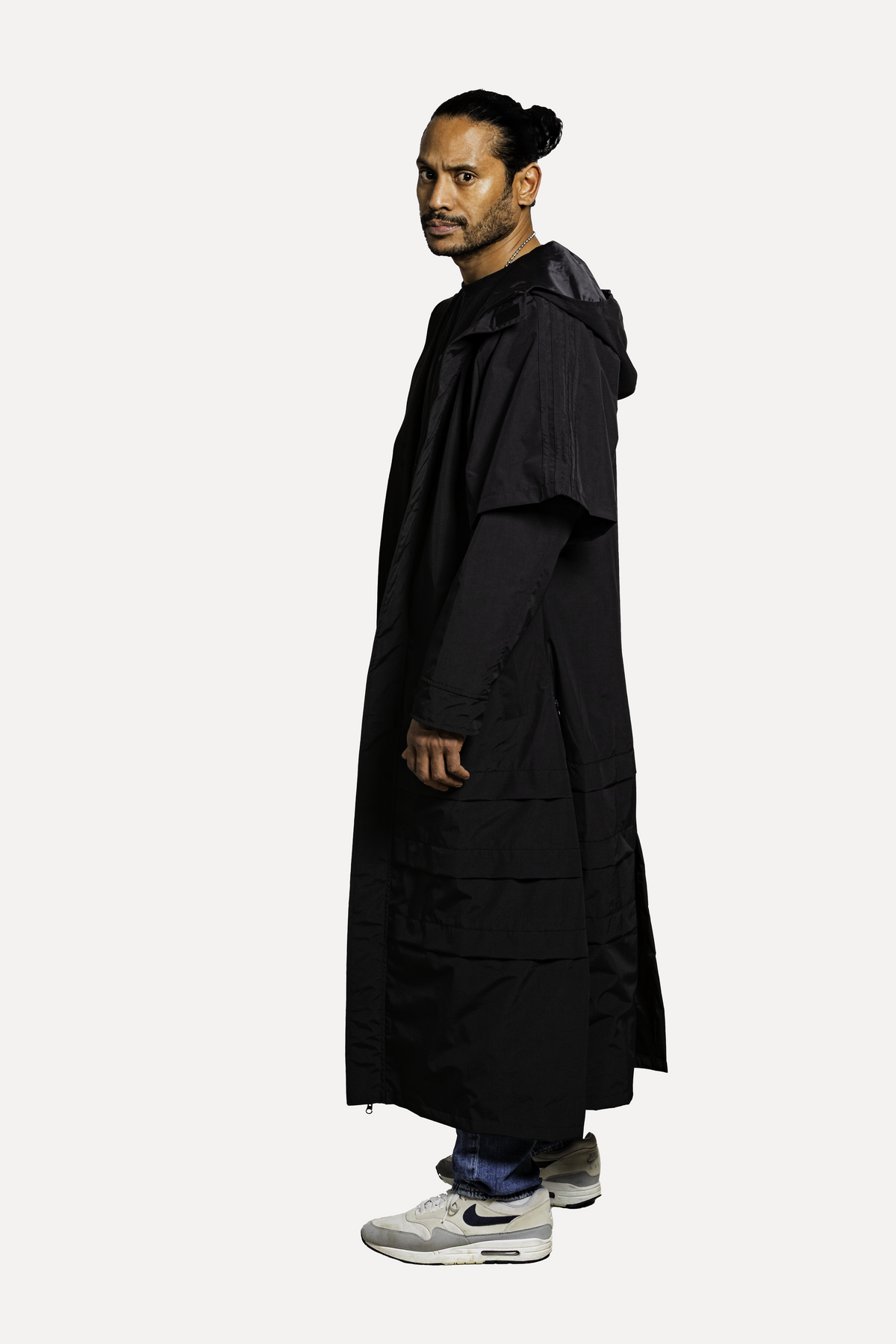 Model in The Sentinel, een lange zwarte ponchojas uit het MATAGI-archief.